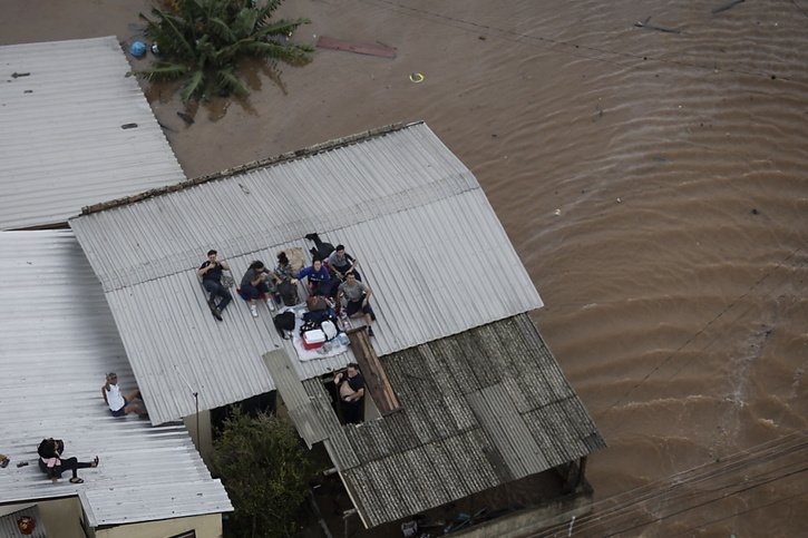 Des personnes attendent sur le toit de leur maison d'être secourues par un hélicoptère de l'armée brésilienne à Porto Alegre au Brésil samedi. © KEYSTONE/EPA/Isaac Fontana